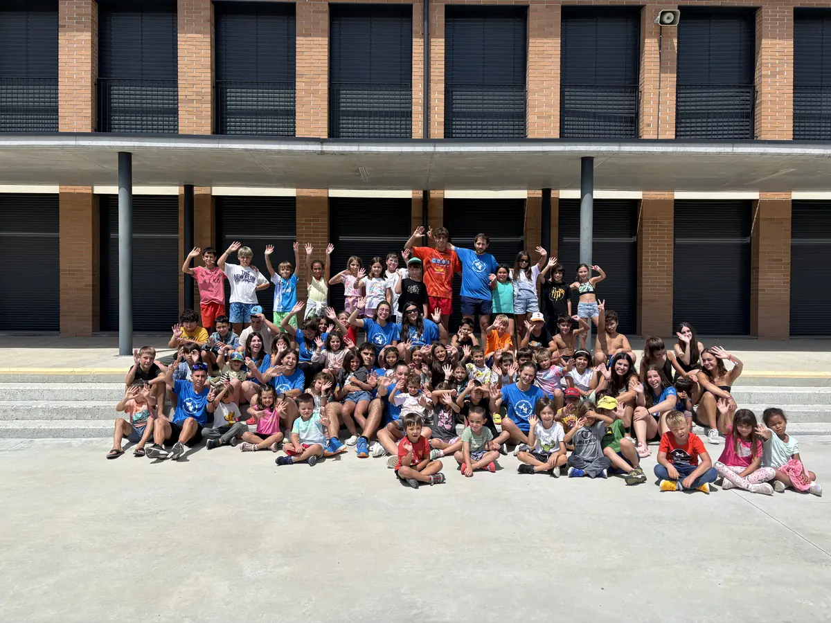 Foto de grup d'un casal d'estiu davant de l'escola